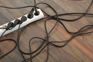 damaged power strip with multiple electrical cords plugged into it